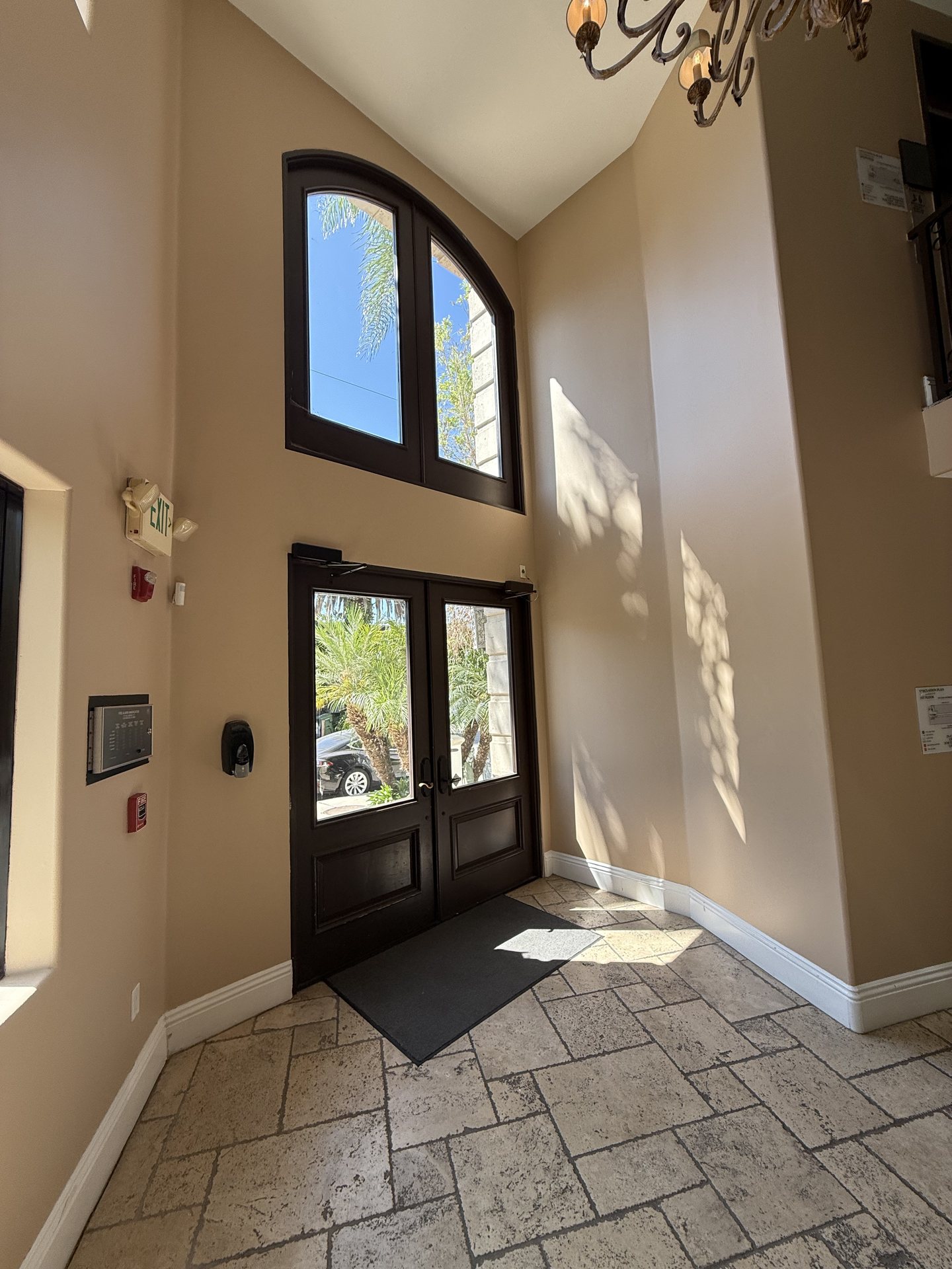Building entry with arched glazing and stone flooring