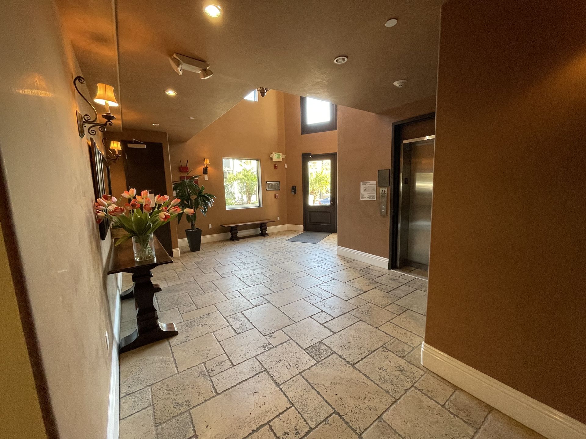 Restored lobby with travertine flooring and elevator