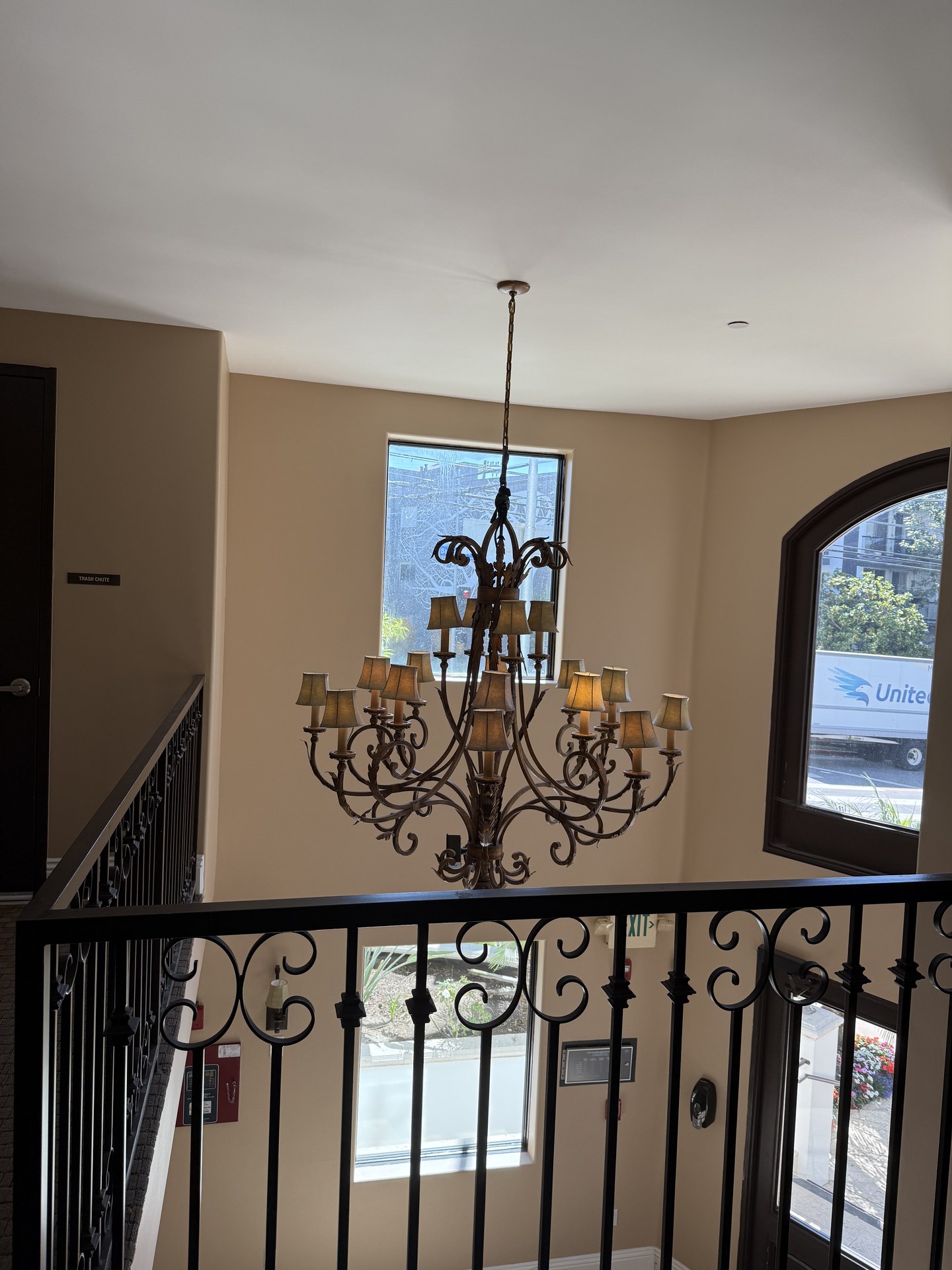 Mezzanine landing with wrought-iron railing and arched window