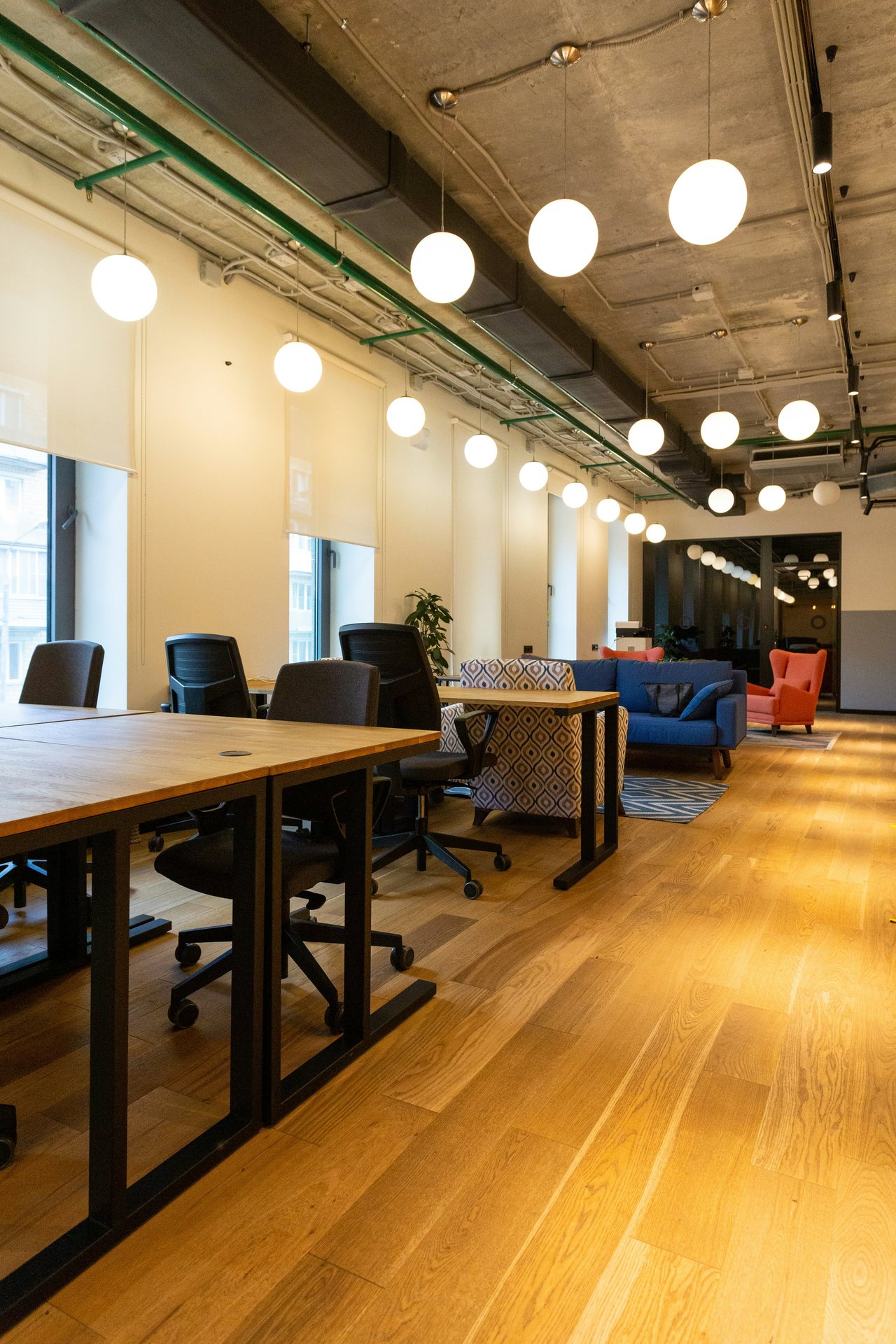 Daylit workspace with wood flooring, globe pendant lighting, and a lounge seating area, Downtown LA office build-out by ASEP Contractors