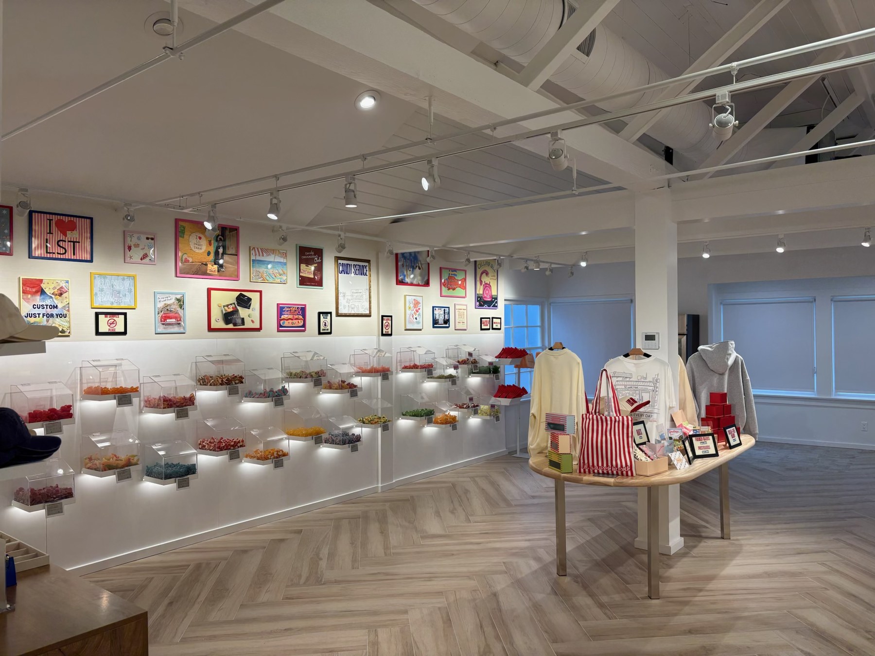 Gallery wall of framed art above candy displays and merchandise table