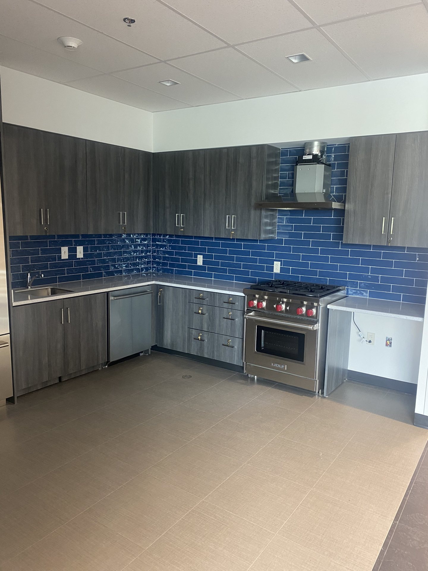 Commercial kitchen with tiled backsplash and range
