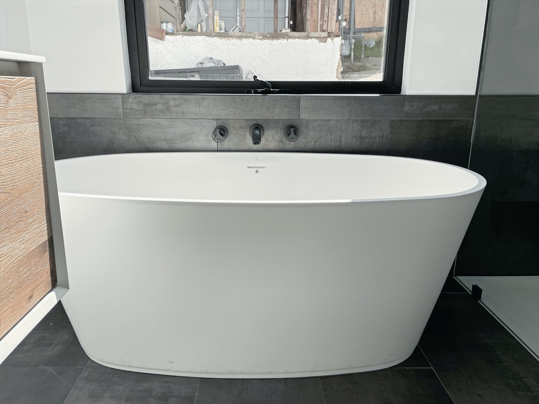 Freestanding soaking tub with porcelain tile surround