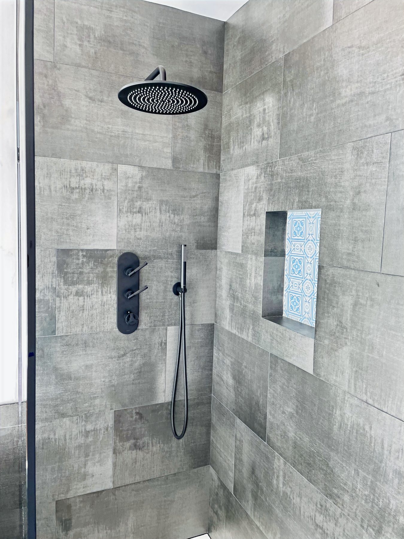 Tiled walk-in shower with rain head and accent niche
